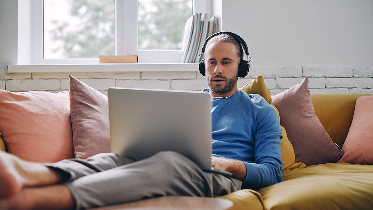 Woman with a laptop sitting on a sofa Woman with a laptop sitting on a sofa